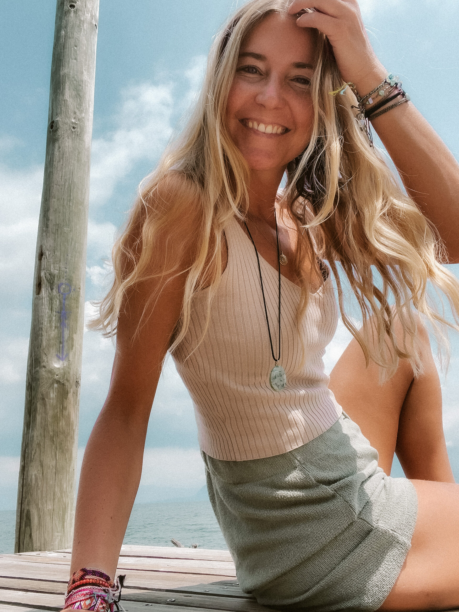 portrait of blonde women sitting on pier in lake Atitlan Guatemala